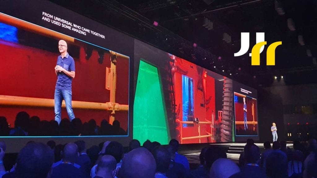 Image of man (Satya Nadella, Microsoft CEO) on large stage with huge screen behind with the man on stage on screen, taken at Microsoft Ignite 2019.