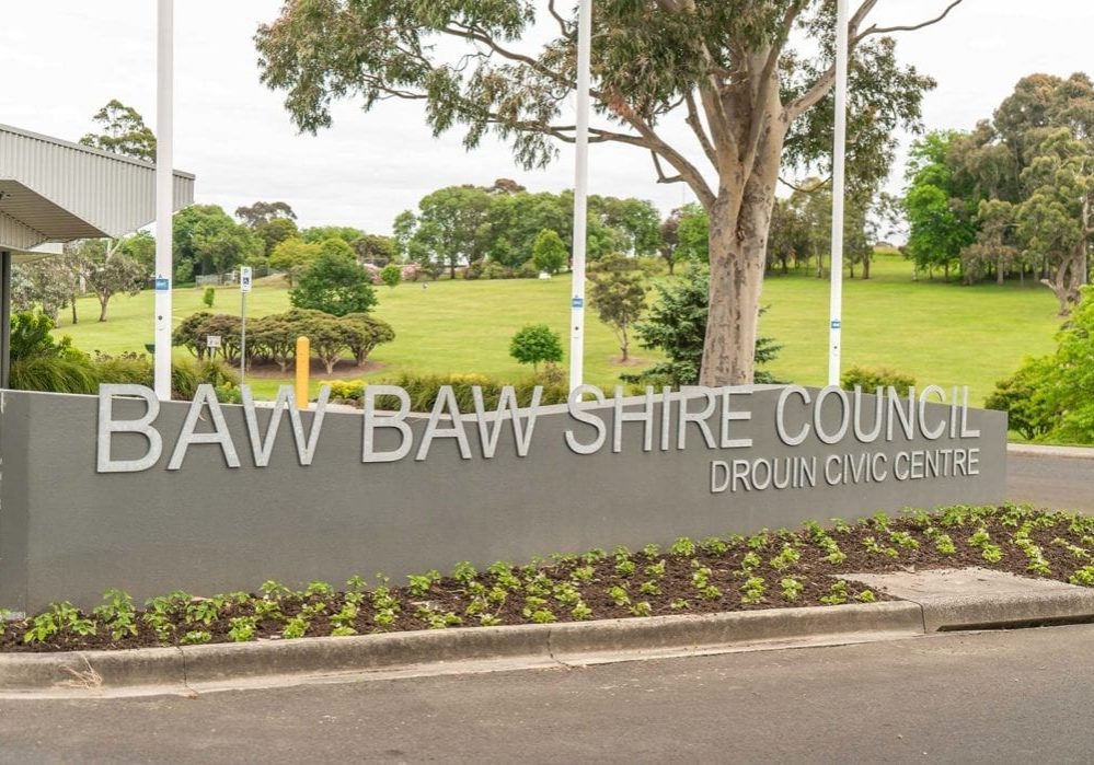 Image of outdoor sign with park and trees behind. Sign says Baw Baw Shire Council.